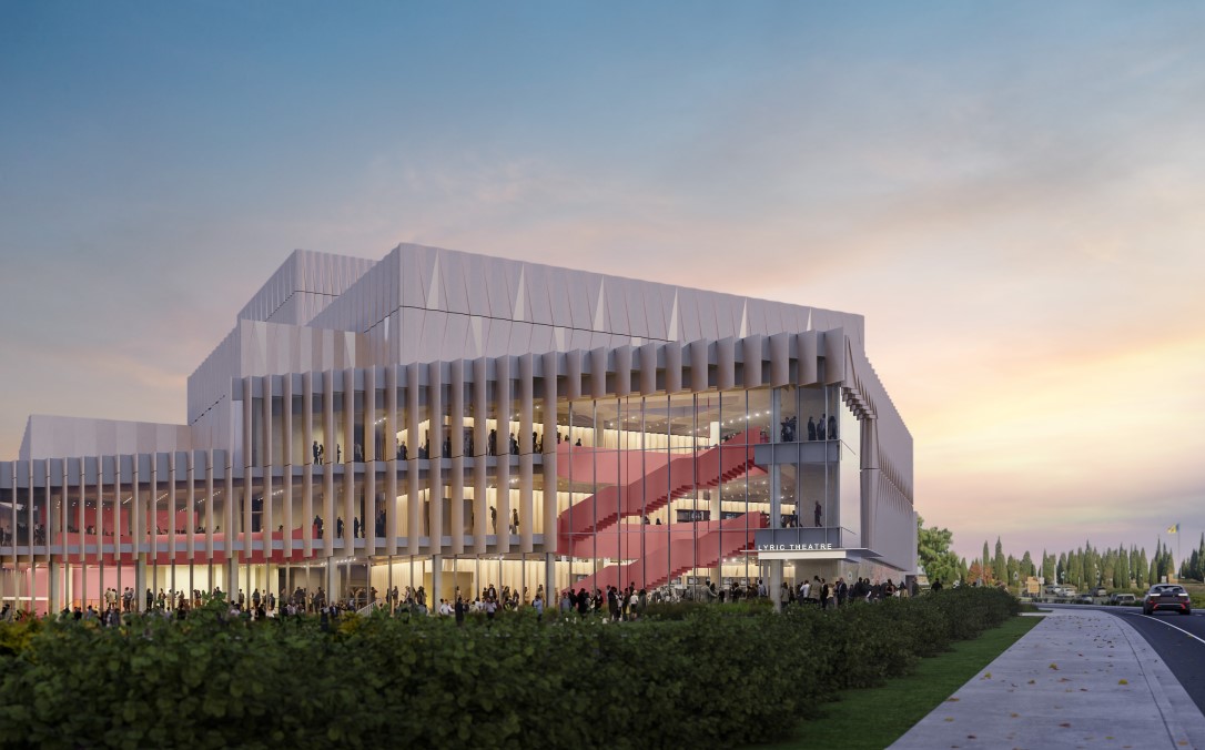 Image shows the architecturally designed building which features vertical panels with largescale windows. It features earthy tones and shows where the building sits next to Northbourne Avenue